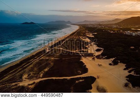 Beach With Dunes, Ocean And Town With Sunset Lights In Campeche, Florianopolis