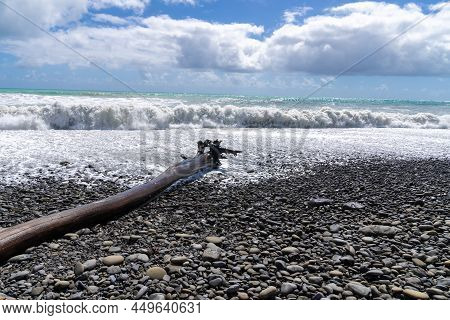 Huge Seas Crashing On Stony Beach At Te Araroa Aound Large Log On Beach, On New Zealand's East Coast