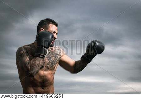 Boxer Practicing Punches In Boxing. Boxer Punching In Boxing Gloves. Sporty Man During Boxing Exerci