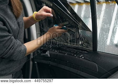 Service Station Worker Fixing Protective Film On Car Windo