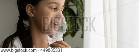 Kid Girl Makes Inhalation With A Nebulizer. Sick Child Holding Inhalator In Hand And Breathes Throug