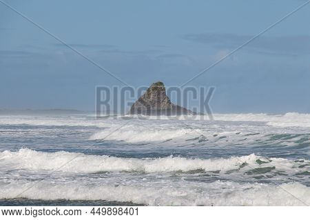 The View Of A Small Rocky Outcrop Between Waves At Karekare Beach, New Zealand.