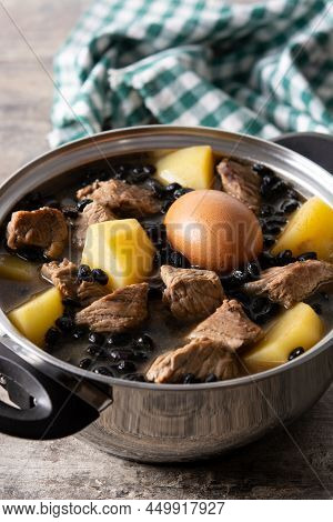 Traditional Jewish Cholent In Casserole On Wooden Table