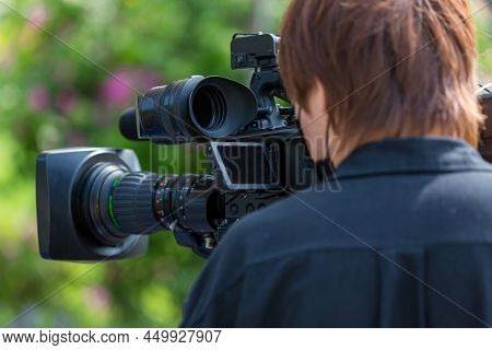 Video Camera Operator Working With His Equipment. Video Cinema Production. Covering An Event With A 