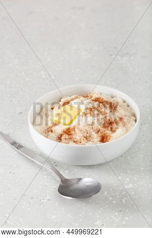 rice pudding with butter cinnamon. french riz au lait, norwegian risgrot, traditional breakfast dessert
