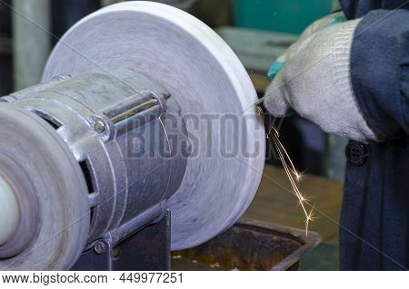 Hands Of Professional Fitter Man Using Metal Polishing Machine For Titanum Metal Rods Sharpening Wit