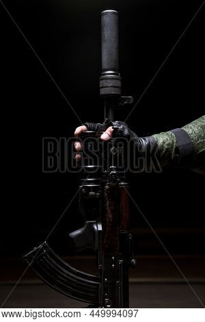 Silenced Kalashnikov Assault Rifle Closeup In The Hand Of The Military. Male Hand Hold A Kalashnikov