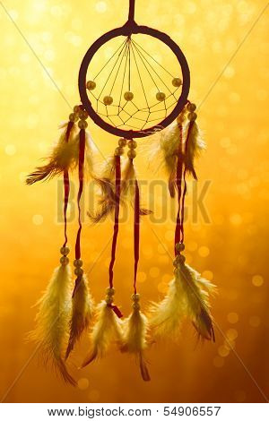 Beautiful dream catcher on yellow background with lights