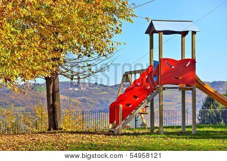 Lone children's slide on empty playground in autumn in small town of Diano D'Alba, Italy.