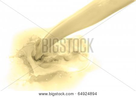 pouring vanilla flavored milk on white background