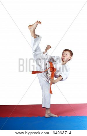 Boy in karatege is doing high kick leg