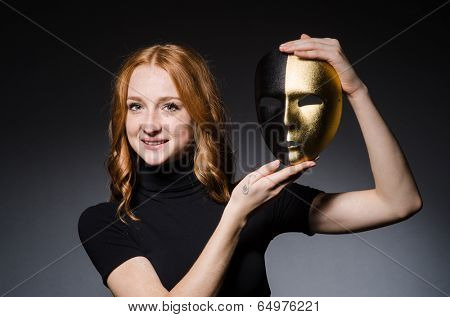 Redhead woman iwith mask in hypocrisy consept against grey background