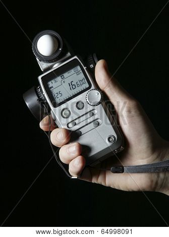 Lightmeter In Hands Isolated On Black