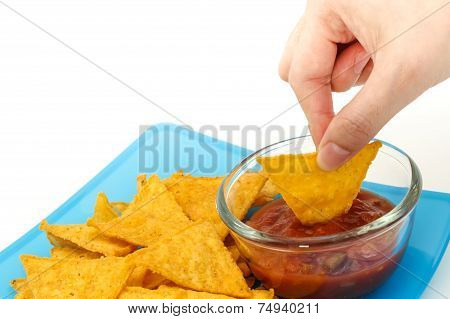 Dipping Tortilla Chips With Salsa Sauce In Dish On White Background