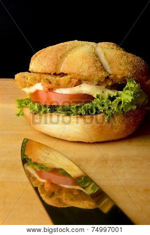 Tasty fish burger with reflection on knife