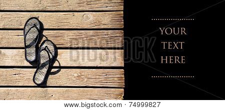 Black flipflops on black background with copyspace