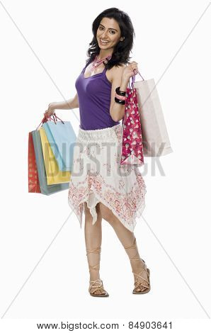 Woman carrying shopping bags and smiling