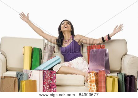 Woman sitting near shopping bags and laughing