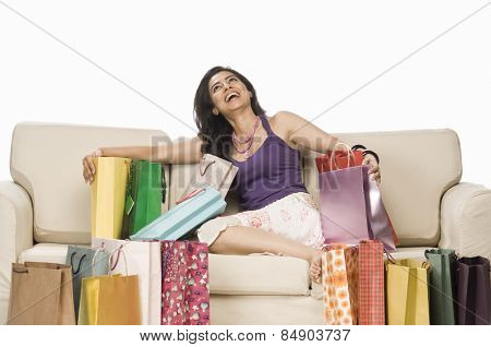 Woman sitting on a sofa and holding a shopping bag