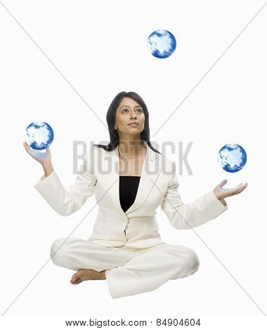 Businesswoman juggling globes