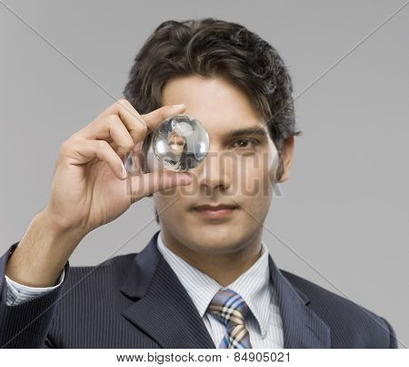Close-up of a businessman looking at a crystal ball