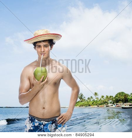 Man drinking coconut milk on the beach