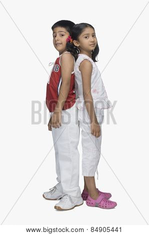 Portrait of two children standing back to back