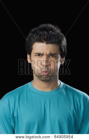 Portrait of a man making a face with puffed cheeks