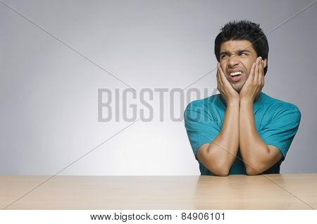 Man leaning on elbows and making a face
