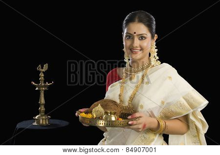 Portrait of a South Indian woman holding a plate of religious offerings