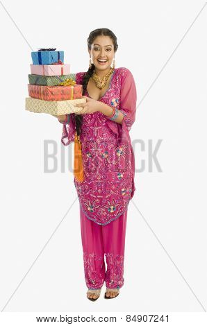 Portrait of a beautiful woman in traditional dress holding gifts and smiling