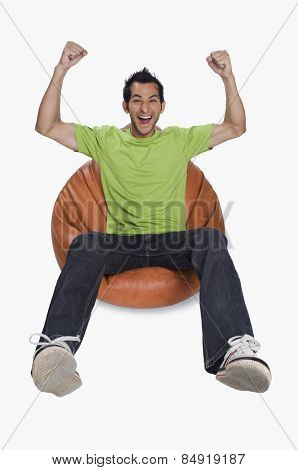 Portrait of a man cheering on a bean bag