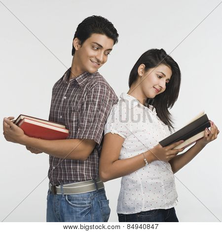 College students standing back to back and reading books