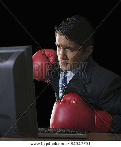 Businessman punching a desktop pc