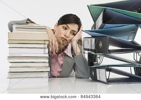 Stack of books in front of a businesswoman at desk