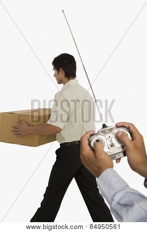 Person's hands controlling a worker with a remote control