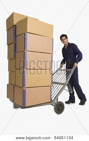 Storekeeper carrying cardboard boxes on hand truck