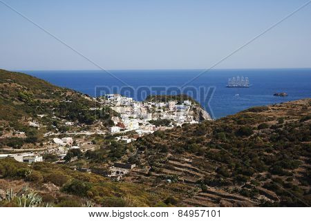 Buildings on a cliff with a clipper ship in the background, Ponza, Tyrrhenian Sea, Province Of Latina, Lazio, Italy