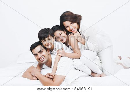 Portrait of a happy family on the bed