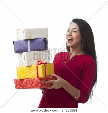 Happy woman holding stack of gifts and smiling