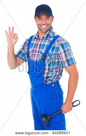 Portrait of happy plumber with plunger gesturing okay on white background
