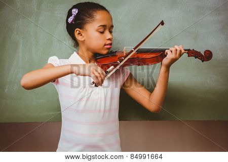 Portrait of cute little girl playing violin in classroom