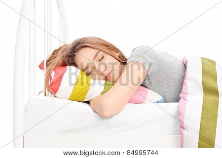 Studio shot of a young woman sleeping in a comfortable bed isolated on white background