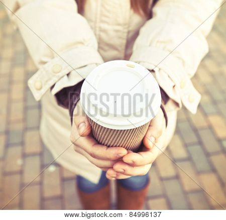 Woman hold cup of coffee on stree