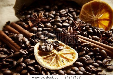 Overturned Bag Full Of Coffee Beans,dried Oranges On Black