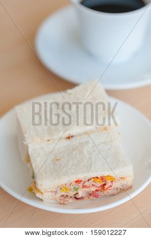 sandwich tuna with hot coffee on table