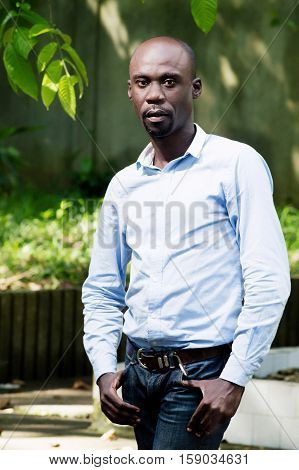 young man standing with hands in pockets looks very worried.