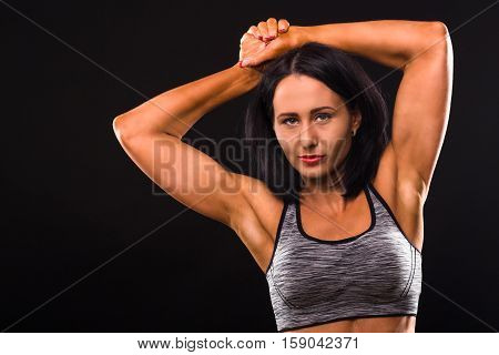 Sports concept. Fitness lady with red lips posing for photographer in studio. Sports lady showing her biceps and smiling for camera.
