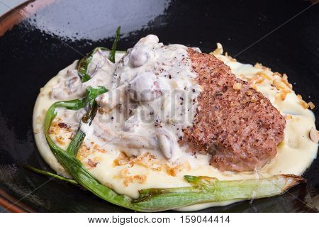 Beef cutlet with mashed potato garnish and mushrooms