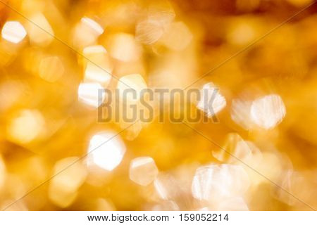 Golden Christmas Bokeh Background. Gold Holiday glowing Abstract Glitter Defocused Background With Blinking Stars. Blurred Backdrop